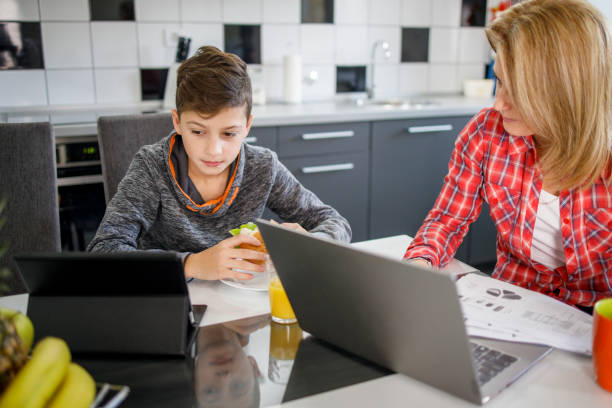 istock Boy having lunch and surfing the internet via digital tablet 1304957818