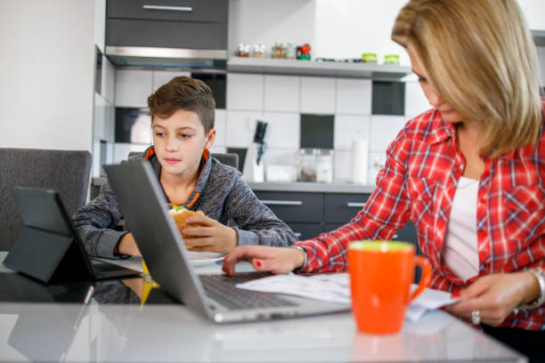 istock Business woman working by her son having lunch 1304957831