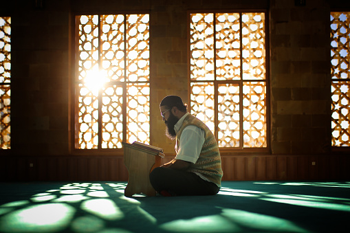 bearded man praying in the mosque