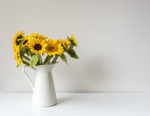 istock Sunflowers in white jug on shelf against wall 1304960254