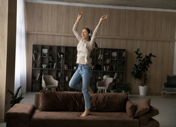 istock Overjoyed millennial Caucasian woman dance on sofa 1304963652