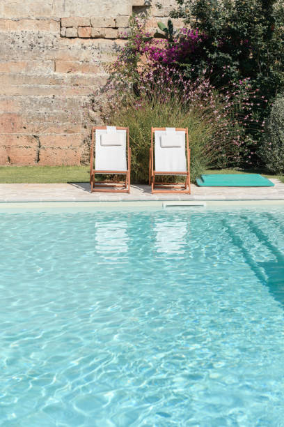 istock Swim pool with clear blue water and sun beds on sunny day 1304964792