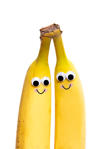 Two bananas still attached with happy faces.