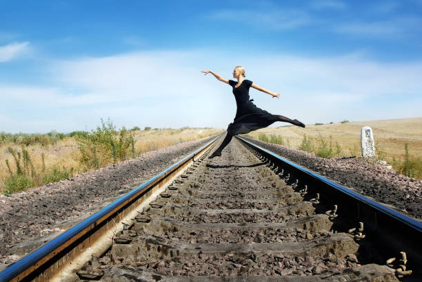istock Ballet dancer jumping over the railroad track 1304966353