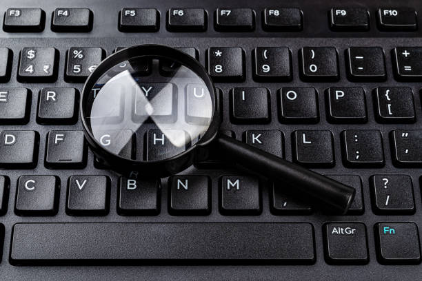 istock Magnifying glass on the black computer keyboard closeup. Find keywords and online resources, network search, Internet security concepts. Detection of computer viruses. 1304970735
