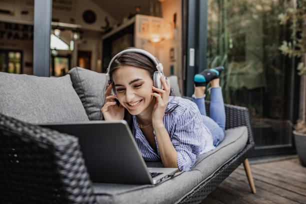 istock Young woman is relaxing while using laptop at home on the balcony 1304973258
