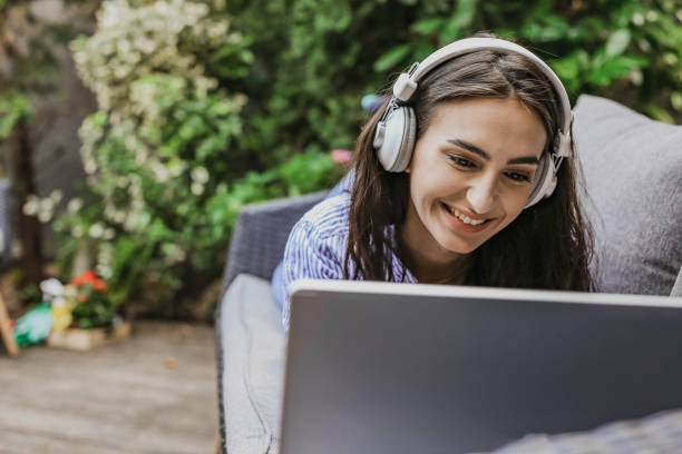 istock Young woman is using laptop at home on the balcony 1304973419