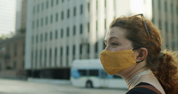 istock Lone Masked Woman Looks Off Camera 1304974148