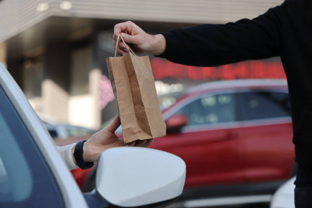 istock Young man picking up his restaurant food from her car 1304977295