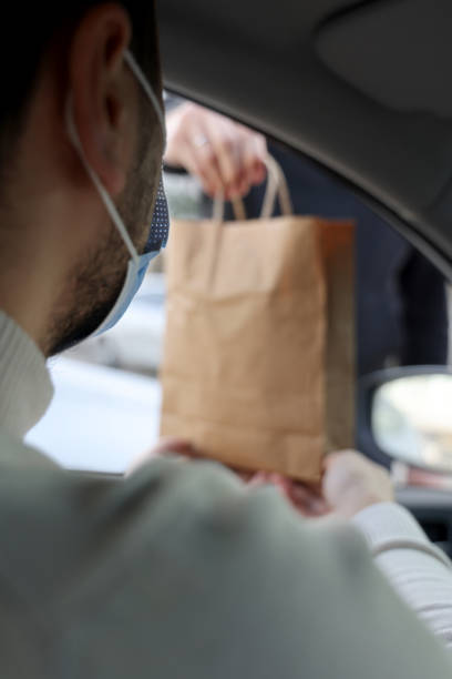 istock Young man picking up his restaurant food from her car 1304977446
