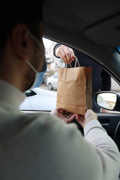 istock Young man picking up his restaurant food from her car 1304977539