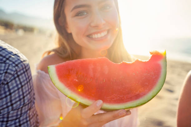 istock Woman eating watermelon and looking at the camera. 1304977656