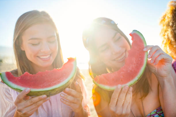 istock Two women eating healthy watermelon fruit. 1304977671