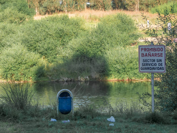 istock Sign in spanish, no swimming, with trash can 1304980022