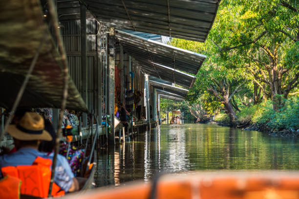 célèbre marché flottant en thaïlande, touristes visitant par bateau. - damnoen saduak floating market photos et images de collection