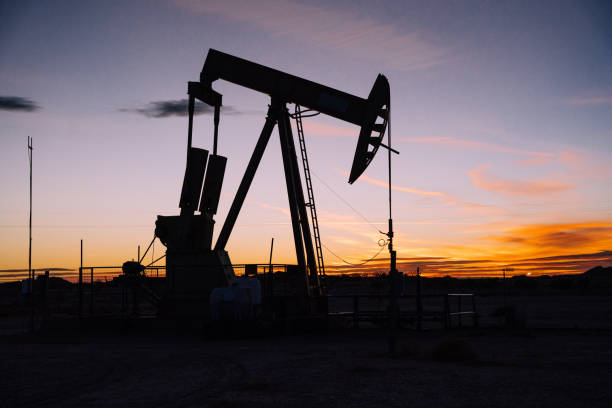 oil pump jack al atardecer en el nuevo desierto mexicano - oil industry industry new mexico oil drill fotografías e imágenes de stock