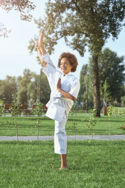 istock Cute female child karateka doing exercise outdoors 1304987066