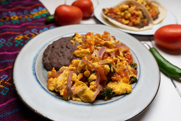 istock Scrambled eggs and refried beans on white background. Mexican food 1304988944