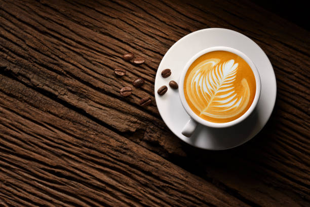 top view of cup of coffee latte tree shape and coffee beans on old wooden background - cappuccino latté coffee coffee cup imagens e fotografias de stock