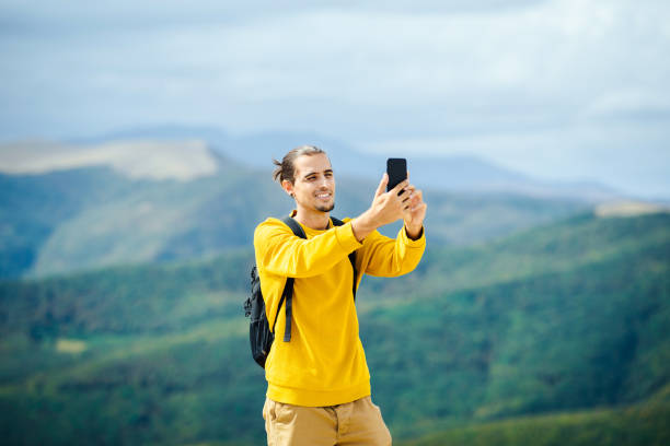 istock Man using cell phone on mountain top stock photo 1304999369