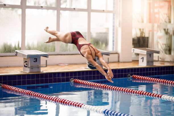 istock Female swimmer diving into pool 1305000252