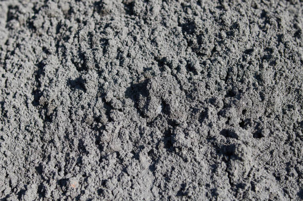 istock wet fresh lumps of concrete with gate polls and a spayed in the background. 1305000490