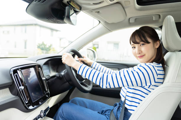 giovane donna asiatica alla guida di un'auto. - car insurance women driving foto e immagini stock