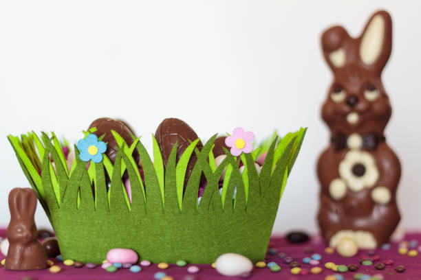 istock Easter basket with chocolate eggs, chocolate bunny and sweets on table 1305008355