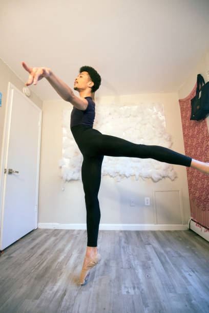 istock Young black male ballet dancer on pointe in home studio. 1305009876