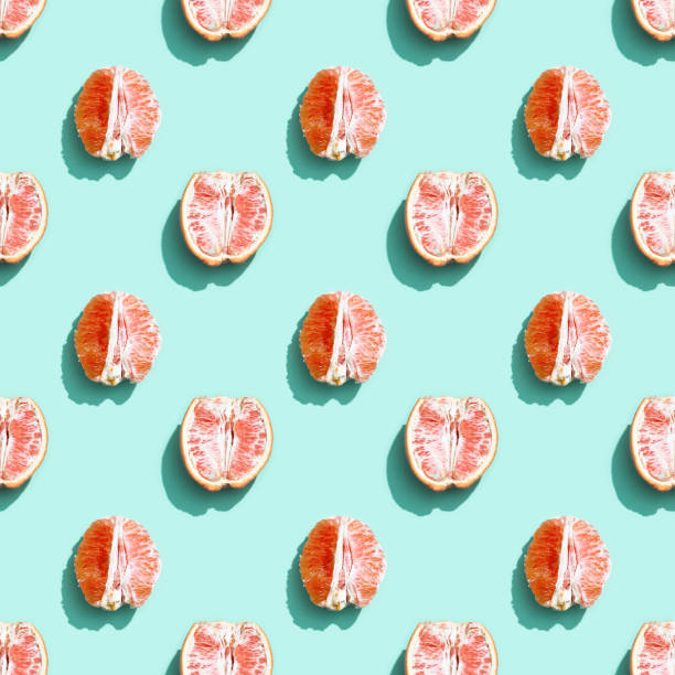 istock Pattern with red without peel orange or grapefruit on bright turquoise. Minimal summer fruits concept. 1305010794