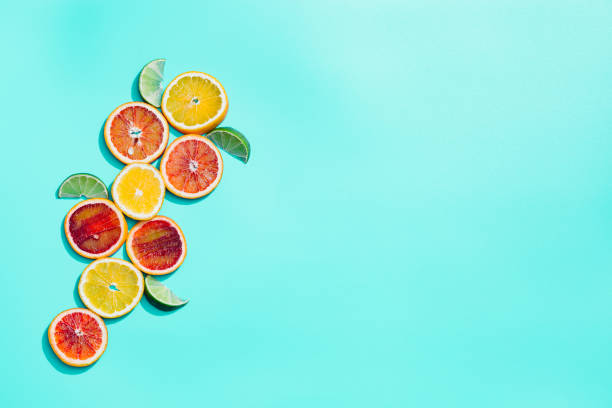 istock Bright slices citrus fruits, grapefruit, red orange, lemon, lime on pastel turquoise background. Minimal fruit and summer concept. 1305010854