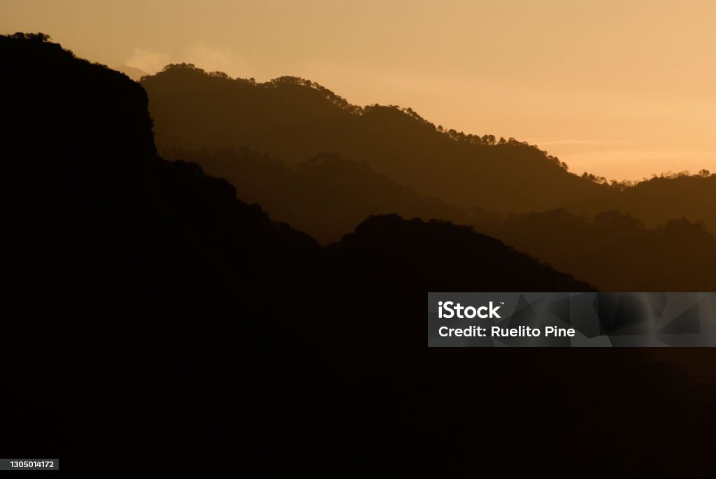 Outline of mountainn ridges in the morning Image showing the silhouette of mountain ridges or range early in the morning depicting calm or tranquility Adventure Stock Photo