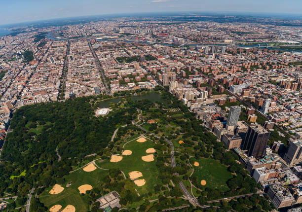 Aerial view of Central Park, Manhattan, and Harlem, and The Bronx in a distance behind, from a helicopter on a sunny summer day. Aerial view of New York City from a helicopter on a sunny summer day. harlem park stock pictures, royalty-free photos & images