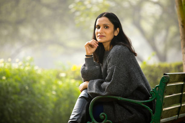 istock Thoughtful woman sitting on bench 1305017311