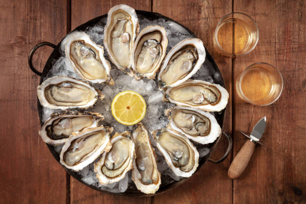 istock Oysters with wine, lemon, and a shucking knife 1305020289