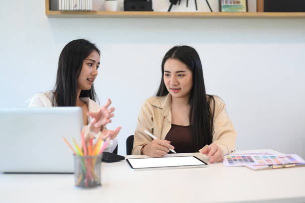 istock Young female designer having friendly discussion and discussing their project in office. 1305024636