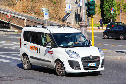Rome, Italy - August 1, 2014: White taxi car Fiat Doblo in the city street.