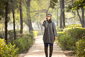 Woman talking on mobile phone while walking at park