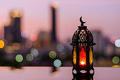Ramadan Kareem lantern with city light background.