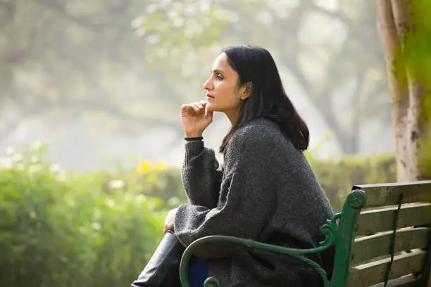 Photo of Thoughtful woman sitting on bench