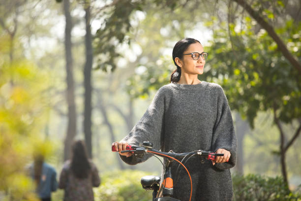 istock Woman walking and pushing bicycle at park 1305026912