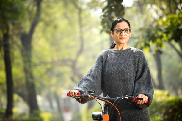 istock Woman walking and pushing bicycle at park 1305027652