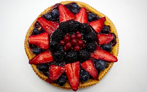 istock Fresh fruit tart with strawberries, raspberries, blackberries, isolated on white background 1305029930