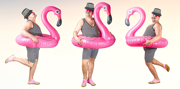 Cheerful man in a striped suit posing isolated over pink wall background holding flamingo rubber ring .Collage.