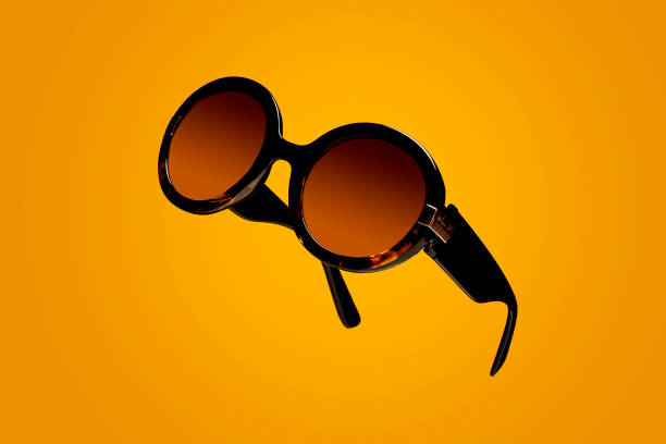 Floating womens sunglasses on a yellow background