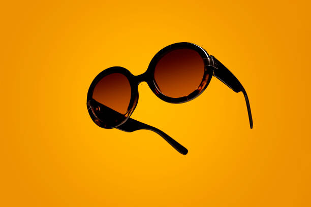 istock Female sunglasses floating on a yellow background 1305033123