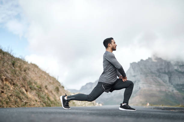 я беру время, чтобы размять ноги перед тренировкой - stretching стоковые фото и изображения