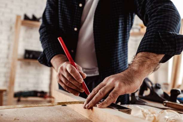 istock Carpenter makes pencil marks on a wood plank 1305035658