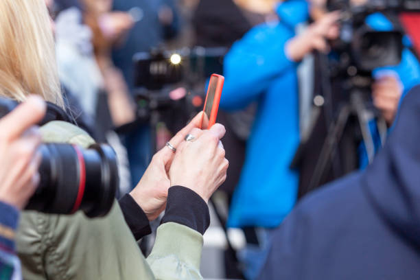 Press or news conference, mobile journalist filming media event with a smartphone stock photo