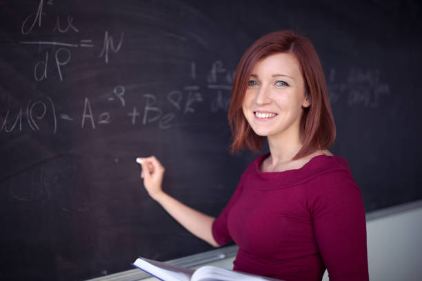 istock Pretty, young college student writing on the chalkboard during a math class 1305046733